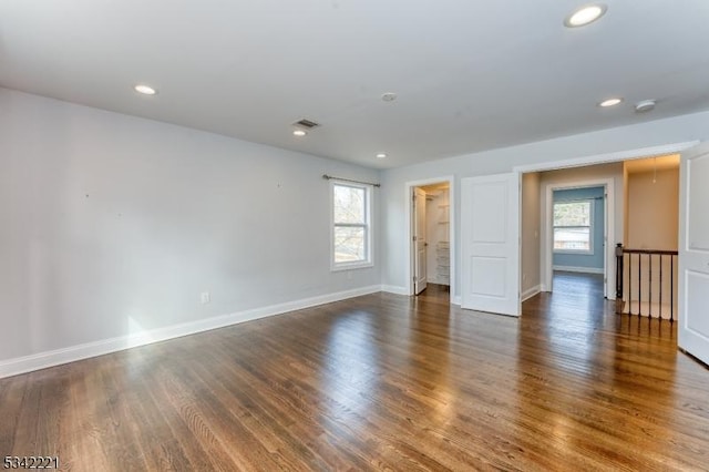 unfurnished room featuring recessed lighting, plenty of natural light, baseboards, and wood finished floors