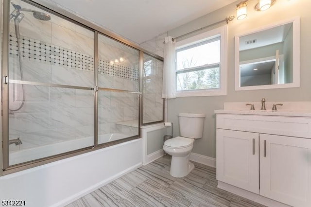 full bathroom with baseboards, visible vents, toilet, shower / bath combination with glass door, and vanity