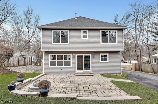 back of property with a fire pit, a patio area, fence, and entry steps