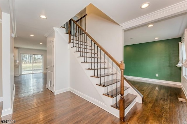 stairway featuring crown molding, baseboards, wood finished floors, and recessed lighting