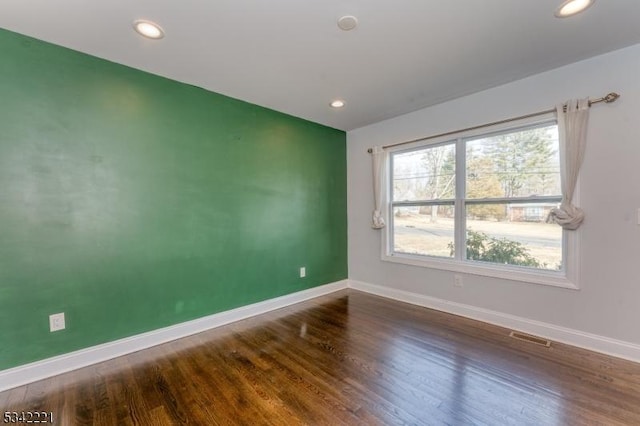 unfurnished room featuring recessed lighting, visible vents, baseboards, and wood finished floors