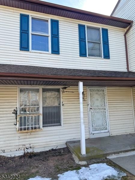 view of front of property with a porch and roof with shingles