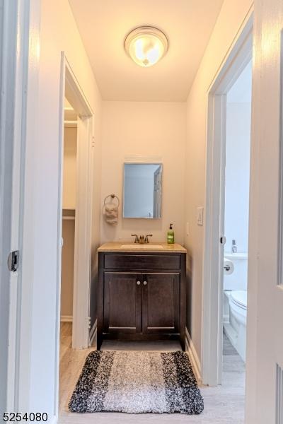 bathroom with baseboards, vanity, and toilet