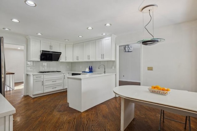 kitchen featuring gas cooktop, white cabinets, light countertops, and tasteful backsplash