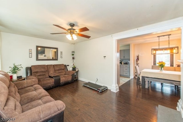 living room with dark wood-style floors, ceiling fan, and baseboards