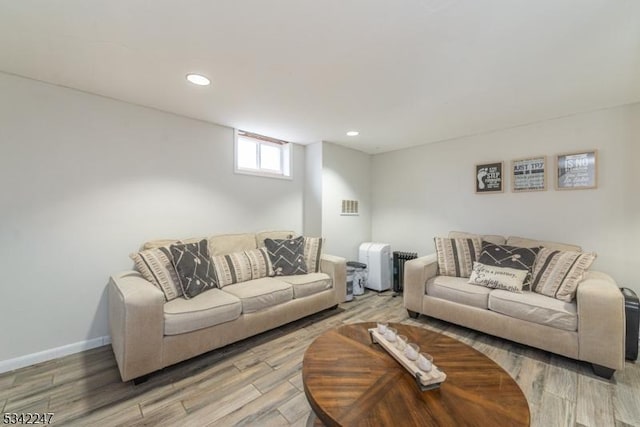 living room featuring recessed lighting, baseboards, visible vents, and light wood finished floors