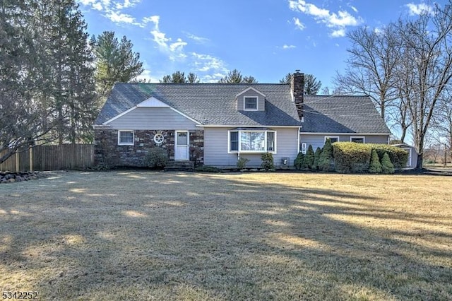 view of front of home with a front yard, fence, and a chimney