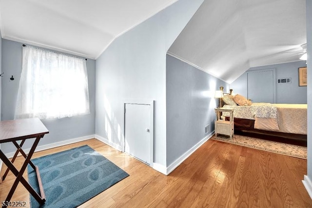 interior space featuring lofted ceiling, baseboards, visible vents, and wood finished floors