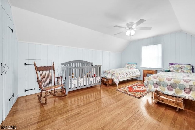 bedroom with a ceiling fan, lofted ceiling, and wood finished floors