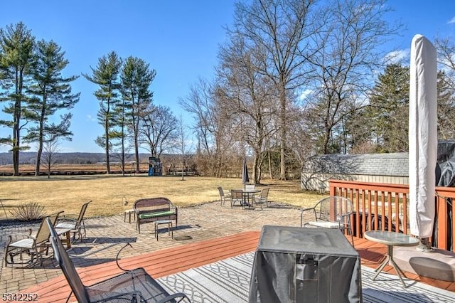 wooden terrace with a lawn and outdoor dining space