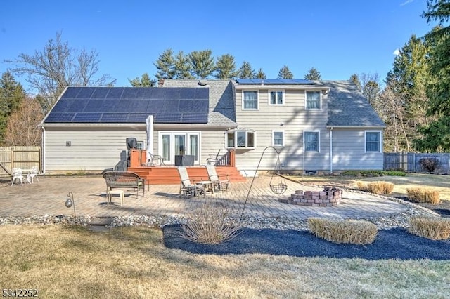 rear view of property with a fire pit, a patio area, and fence