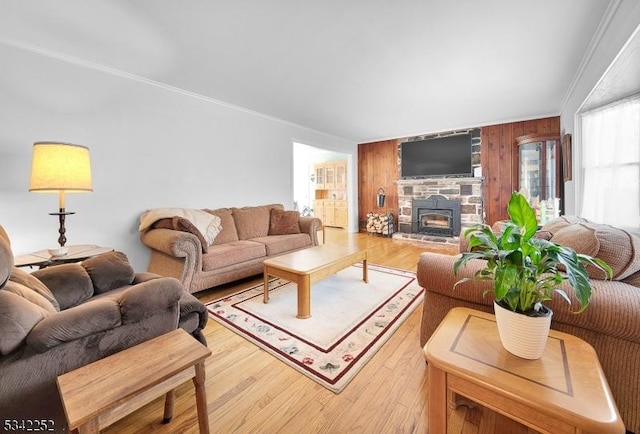 living area with ornamental molding, wood walls, a fireplace, and wood finished floors