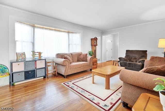 living area with ornamental molding and wood finished floors