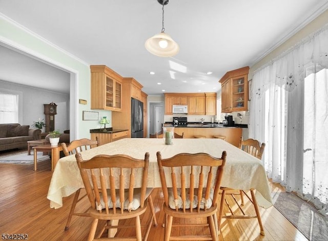 dining space with crown molding, recessed lighting, and light wood-style floors