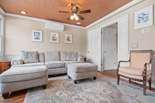 living area with crown molding, ceiling fan, wainscoting, wood finished floors, and a wall mounted AC