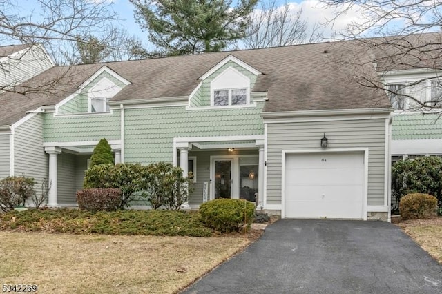 townhome / multi-family property with an attached garage, aphalt driveway, and a shingled roof