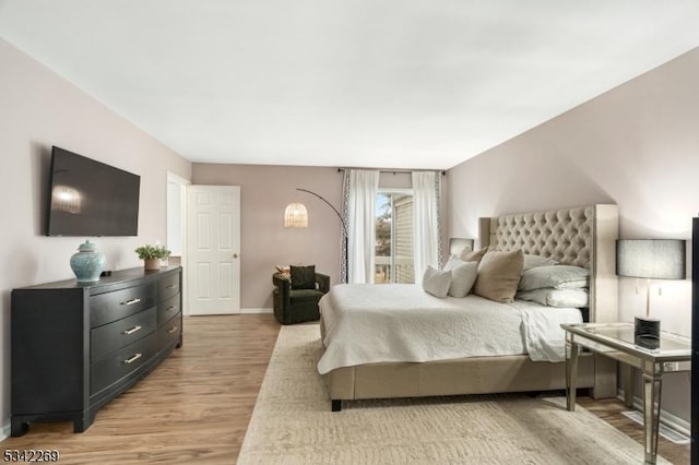 bedroom with light wood finished floors and baseboards