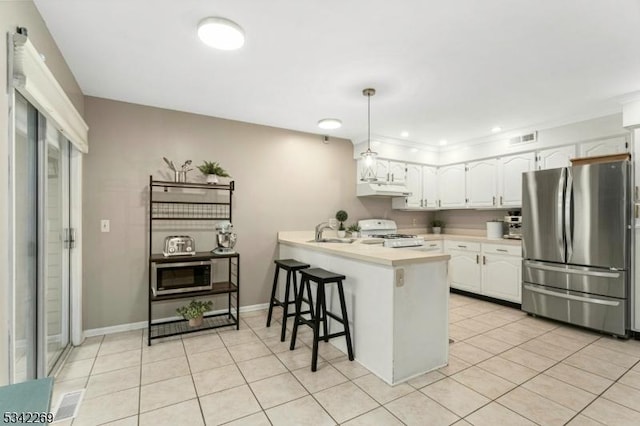 kitchen featuring light countertops, appliances with stainless steel finishes, white cabinets, a peninsula, and under cabinet range hood