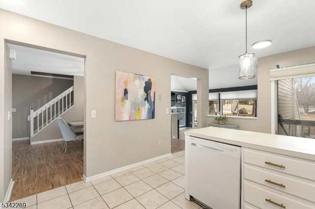 kitchen featuring light tile patterned flooring, white cabinetry, light countertops, dishwasher, and decorative light fixtures