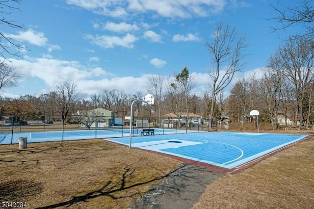 view of basketball court featuring a lawn, community basketball court, and fence