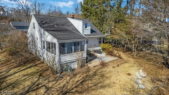 rear view of property featuring a sunroom