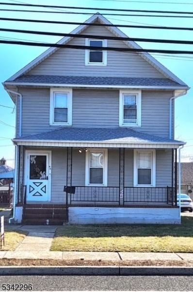 american foursquare style home featuring covered porch and roof with shingles