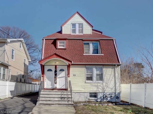 view of front of home with roof with shingles and fence