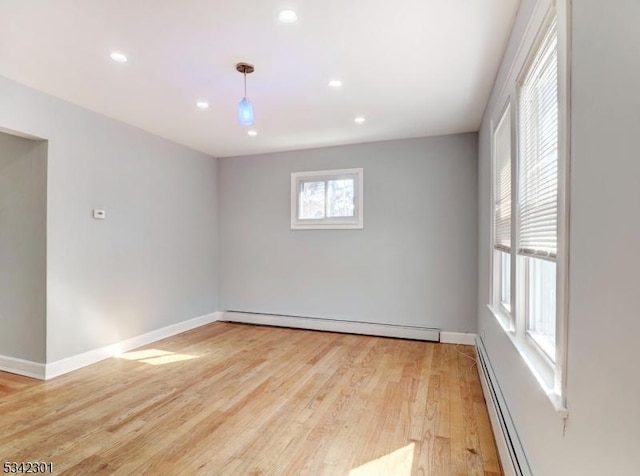 spare room featuring recessed lighting, baseboards, light wood-style floors, and baseboard heating