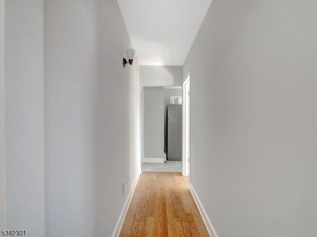 hallway with light wood finished floors and baseboards