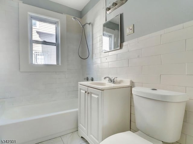 full bath featuring shower / washtub combination, vanity, toilet, and tile walls