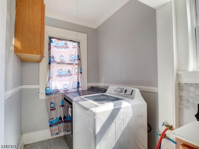 washroom with tile patterned flooring, independent washer and dryer, cabinet space, and baseboards