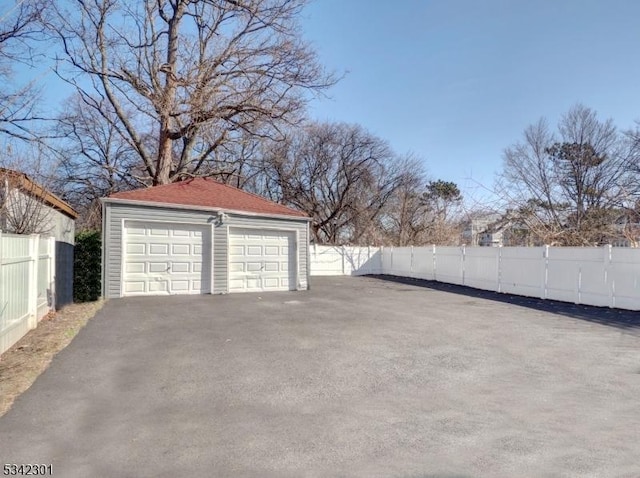 detached garage featuring fence