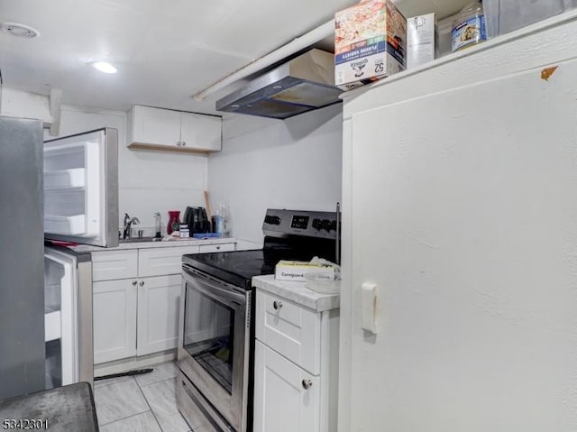 kitchen featuring electric range, light countertops, under cabinet range hood, white cabinetry, and white refrigerator