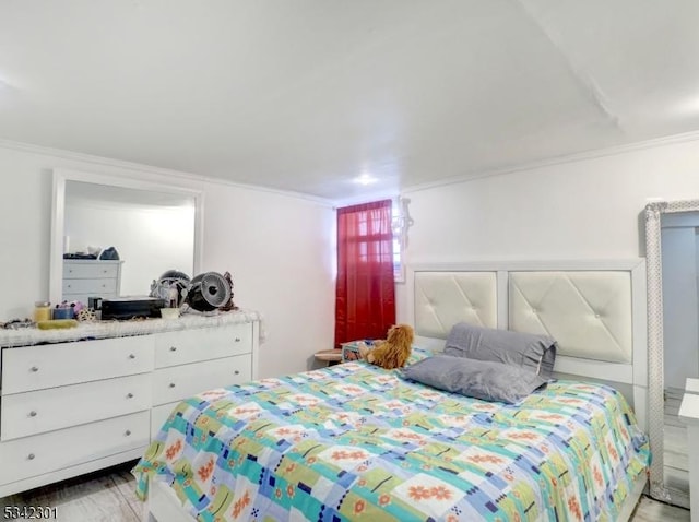 bedroom with light wood-type flooring and crown molding