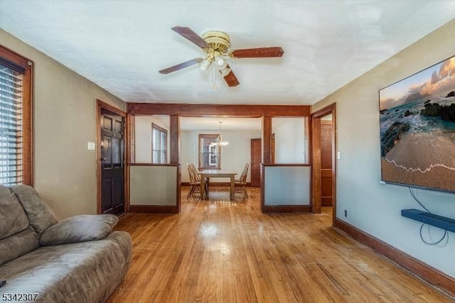 living room with ceiling fan, hardwood / wood-style floors, and baseboards