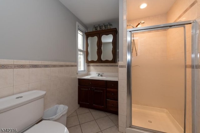 full bathroom with toilet, a stall shower, tile patterned flooring, and tile walls