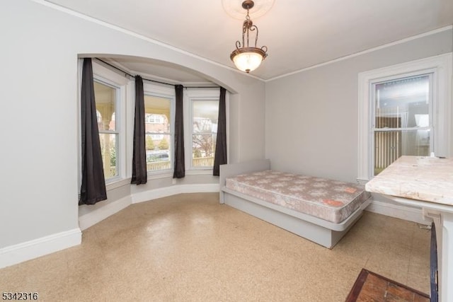 bedroom featuring baseboards, arched walkways, and crown molding