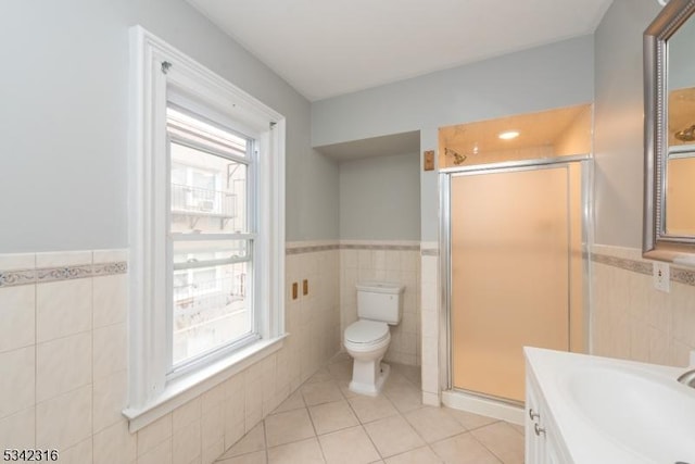 full bathroom with toilet, a shower stall, tile walls, and tile patterned floors