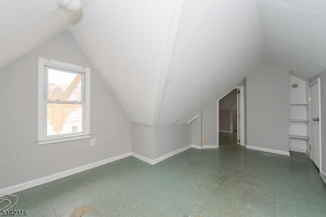 bonus room with lofted ceiling, baseboards, and tile patterned floors