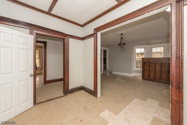 spare room featuring baseboards, light colored carpet, and crown molding