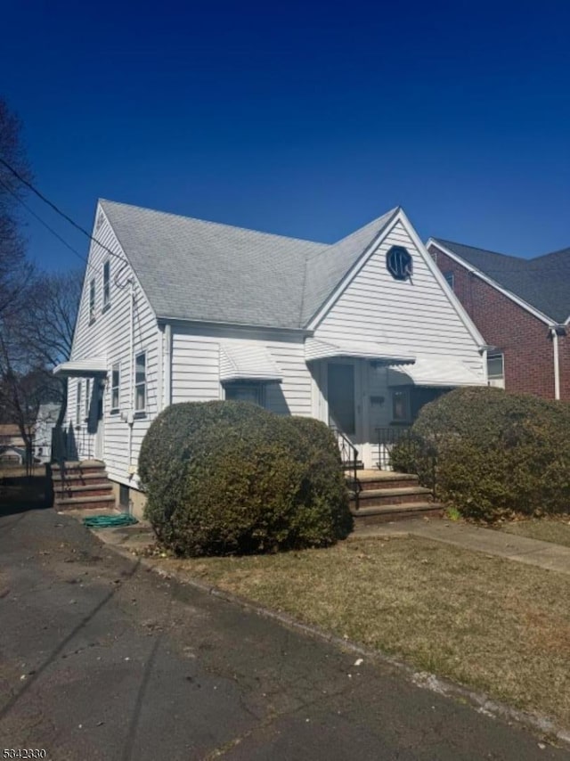 view of front facade featuring roof with shingles