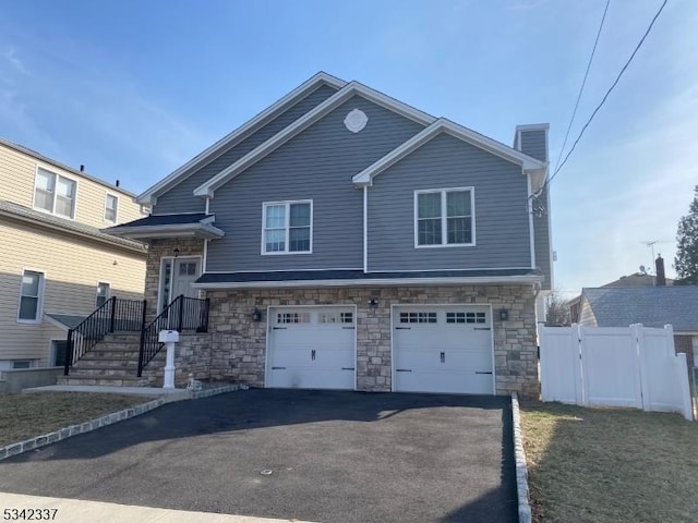 view of front of home featuring stone siding, driveway, a chimney, and an attached garage