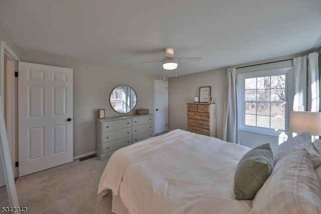 bedroom featuring light carpet, ceiling fan, and baseboards