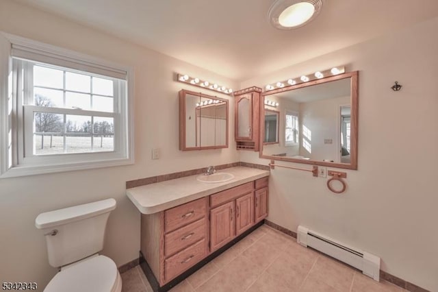 bathroom featuring baseboards, toilet, tile patterned floors, vanity, and a baseboard heating unit