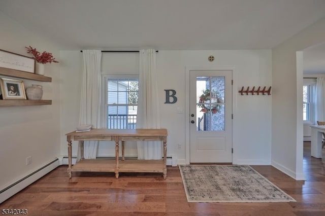 foyer entrance with baseboard heating, plenty of natural light, and wood finished floors