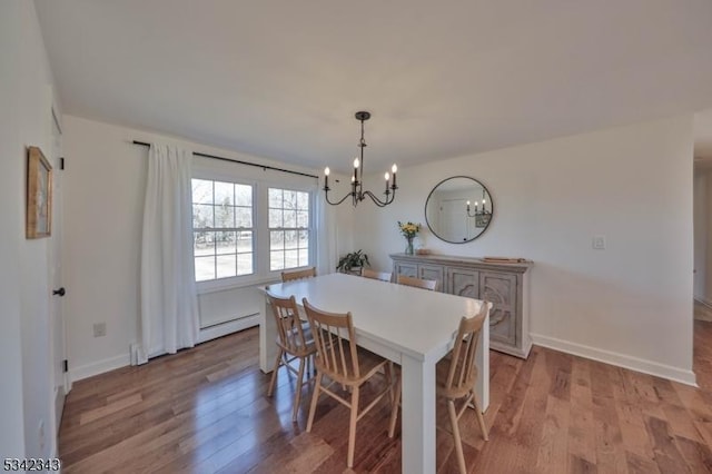 dining room featuring light wood-style floors, baseboards, a baseboard heating unit, and an inviting chandelier