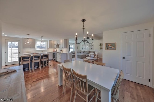 dining room featuring recessed lighting, wood finished floors, and an inviting chandelier