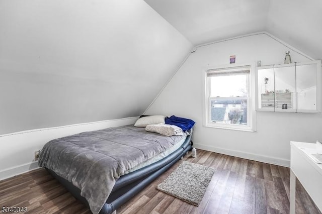 bedroom with lofted ceiling, wood finished floors, and baseboards