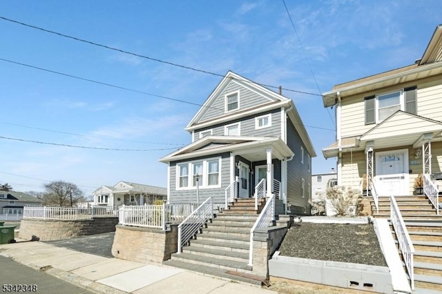 traditional style home featuring covered porch, stairs, and fence