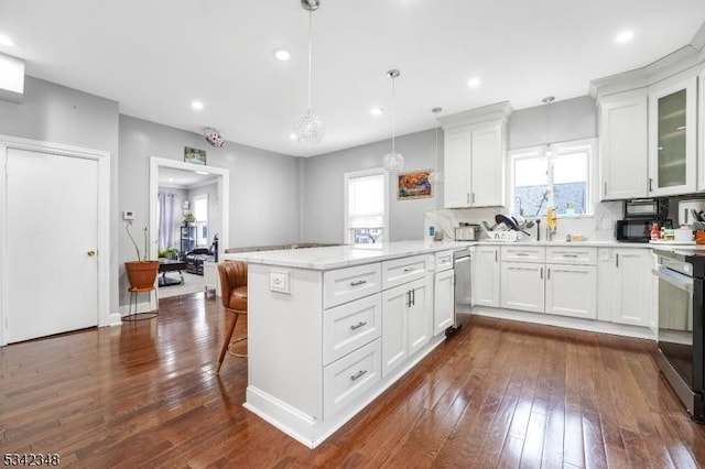 kitchen with a kitchen bar, white cabinets, a peninsula, and dark wood-type flooring